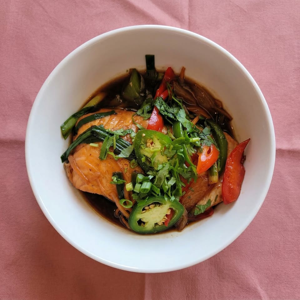 Vietnamese salmon with red peppers, green onions, and jalapeños in a white bowl.